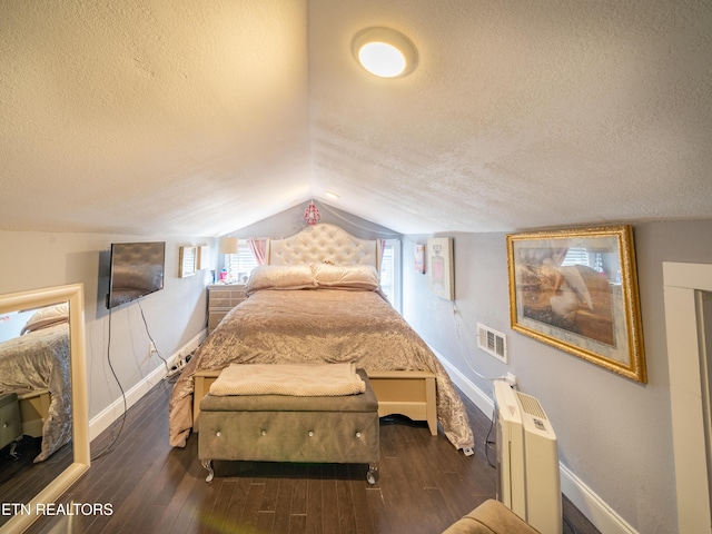 bedroom featuring dark wood-type flooring, radiator heating unit, and a textured ceiling