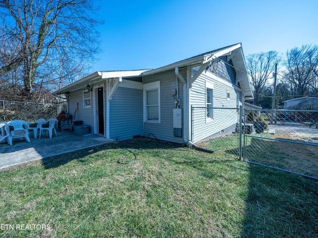 view of side of home featuring a yard and a patio area