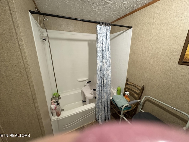 bathroom featuring shower / bath combination with curtain and a textured ceiling