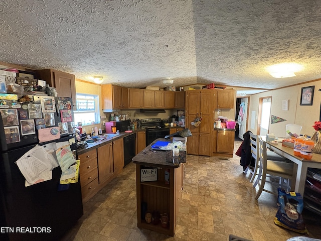 kitchen with sink, a textured ceiling, ornamental molding, a kitchen island, and black appliances