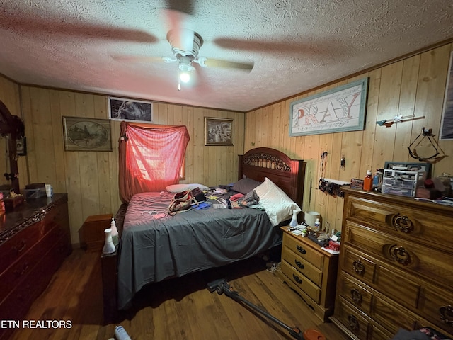 bedroom with ceiling fan, dark hardwood / wood-style floors, and a textured ceiling