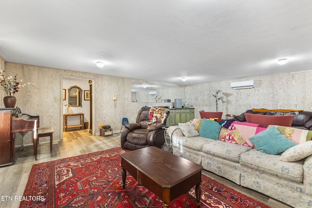 living room with light wood-type flooring and an AC wall unit