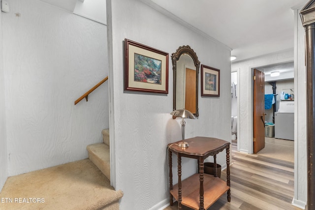 stairway featuring hardwood / wood-style floors and washer / dryer