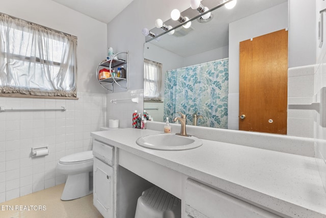 bathroom with vanity, tile walls, and toilet