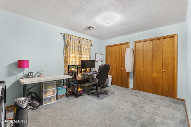 carpeted office with a textured ceiling