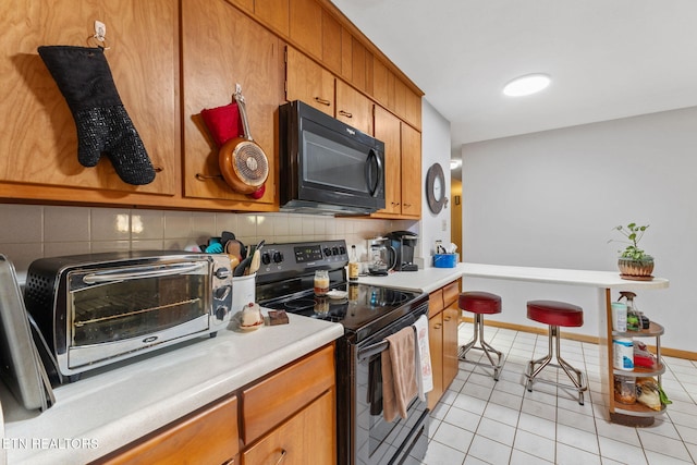 kitchen featuring light tile patterned flooring, backsplash, and electric stove