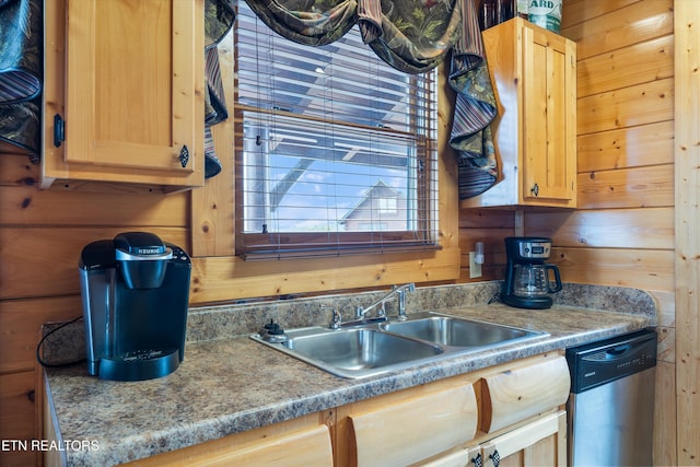 kitchen featuring sink, light brown cabinets, dishwasher, and wood walls