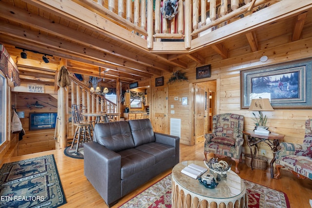 living room with hardwood / wood-style flooring, beamed ceiling, and wood walls