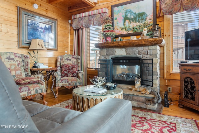 living room with wood-type flooring, a fireplace, and wood walls