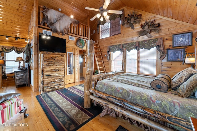 bedroom featuring multiple windows, hardwood / wood-style floors, wooden walls, and wooden ceiling