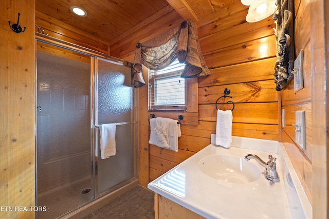 bathroom with walk in shower, vanity, wood ceiling, and wood walls