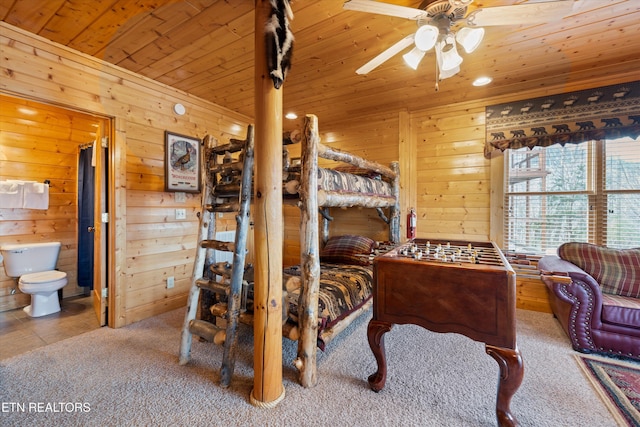 carpeted bedroom with wood ceiling, wooden walls, and ensuite bathroom