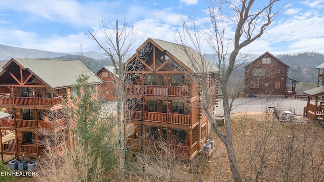 rear view of house featuring a balcony, a mountain view, and central air condition unit