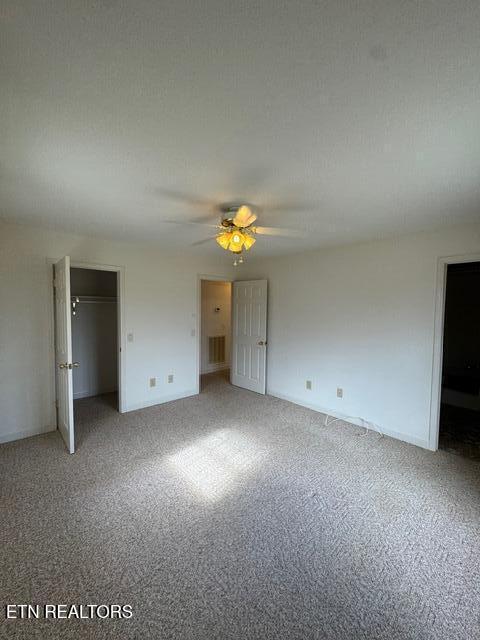 unfurnished bedroom with ceiling fan, carpet, and a textured ceiling