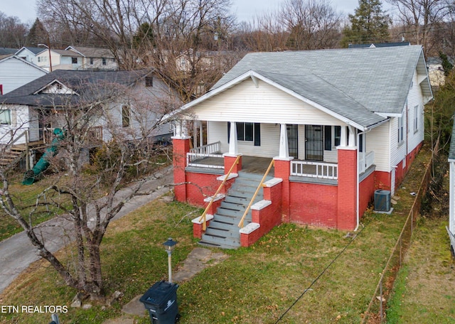 bungalow featuring a porch, cooling unit, and a front lawn