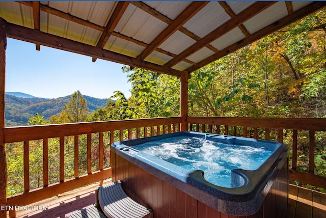 wooden terrace featuring a hot tub and a mountain view