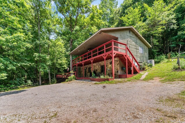 1731 Vonore Rd, Loudon, TN 37774 - rustic home featuring a wooden deck, stone siding, stairway, and a view of trees