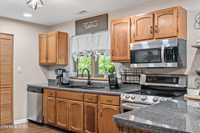 1731 Vonore Rd, Loudon, TN 37774 - kitchen with stainless steel appliances, a sink, dark wood-style flooring, baseboards, and brown cabinetry