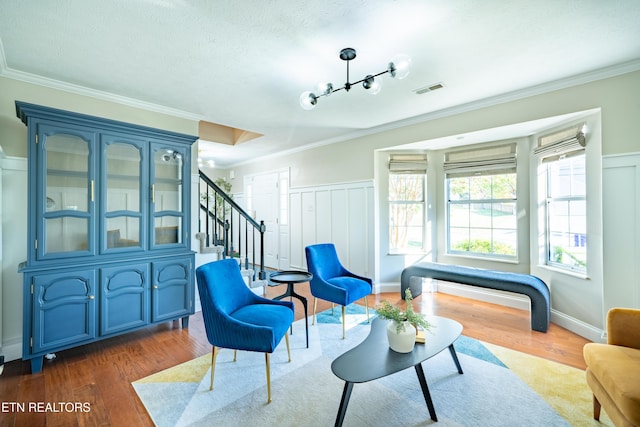 living area with crown molding, dark wood-type flooring, and a textured ceiling