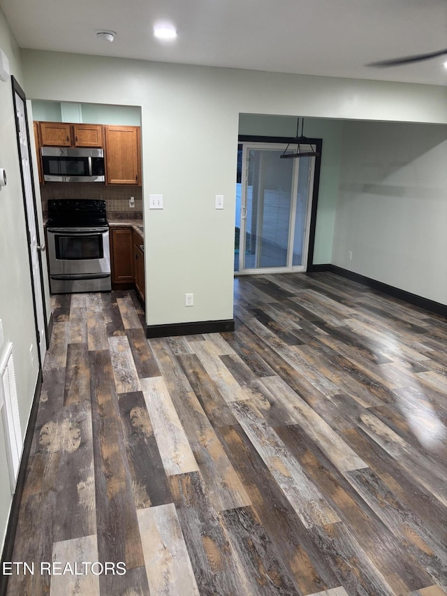 kitchen with tasteful backsplash, stainless steel appliances, and dark hardwood / wood-style floors