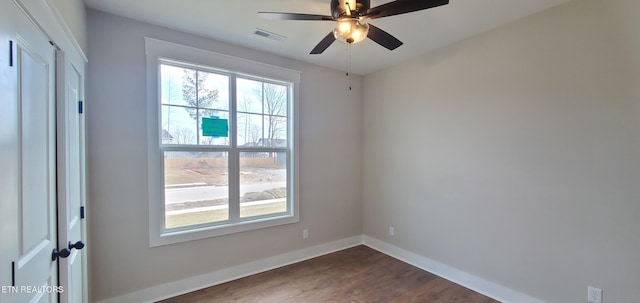 unfurnished room featuring dark wood-type flooring and ceiling fan