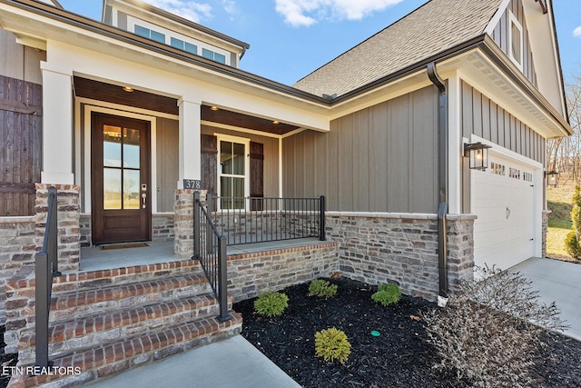 doorway to property with a garage and covered porch