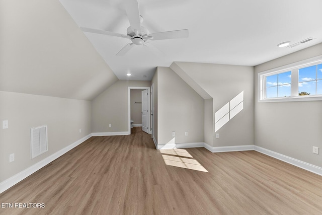 bonus room with lofted ceiling, light wood-style flooring, visible vents, and baseboards