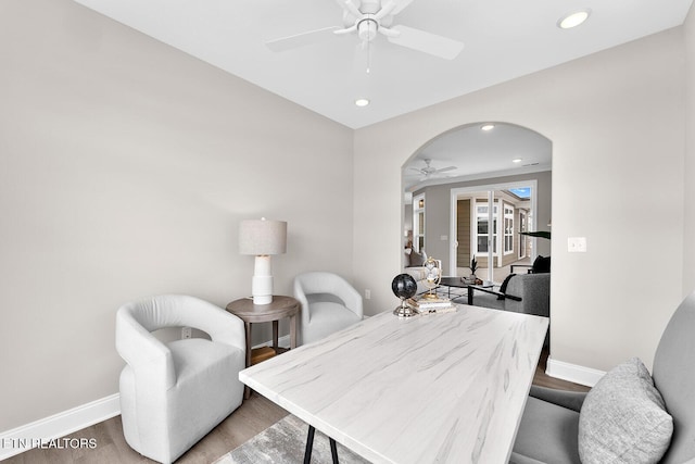 dining area with arched walkways, recessed lighting, a ceiling fan, baseboards, and light wood finished floors