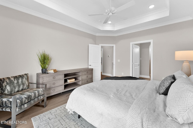 bedroom featuring ceiling fan, wood finished floors, a tray ceiling, crown molding, and recessed lighting