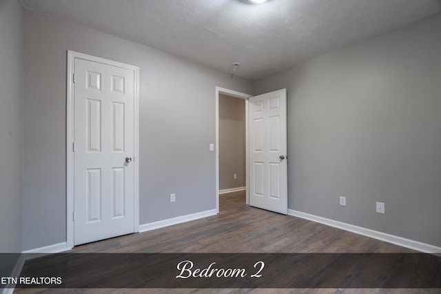 unfurnished bedroom with hardwood / wood-style floors and a textured ceiling