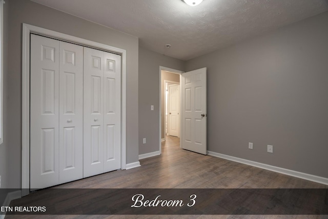 unfurnished bedroom with hardwood / wood-style floors, a closet, and a textured ceiling