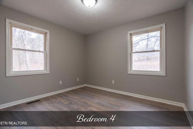 unfurnished room with wood-type flooring