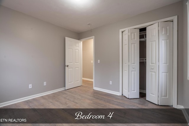 unfurnished bedroom with hardwood / wood-style floors and a closet