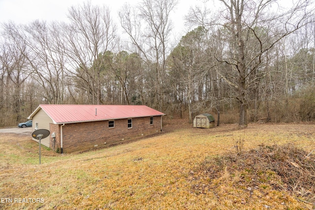 view of home's exterior with a yard and a storage unit