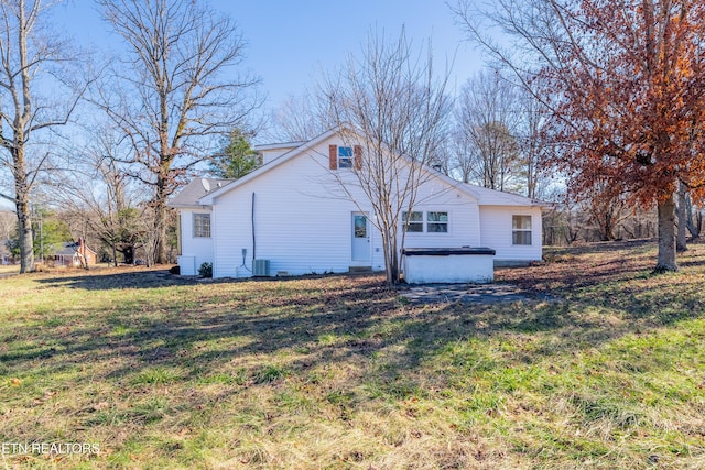 exterior space with central AC unit and a lawn