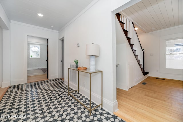 corridor with hardwood / wood-style floors, crown molding, and wooden ceiling