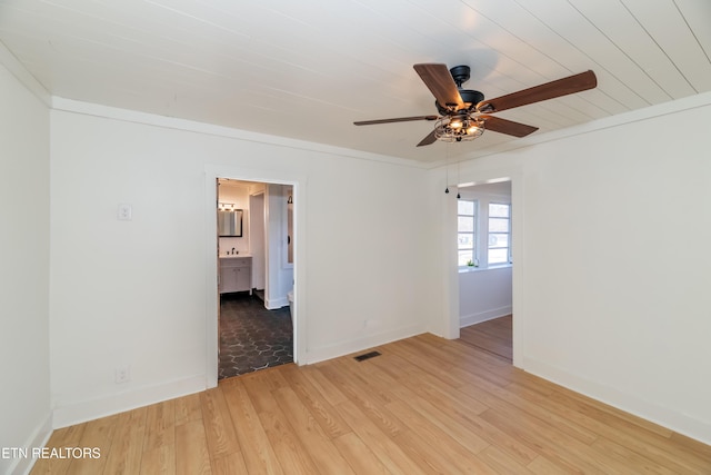 empty room with crown molding, ceiling fan, and light hardwood / wood-style flooring