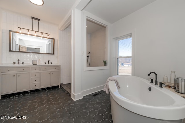 bathroom with vanity, tile patterned floors, and a tub to relax in