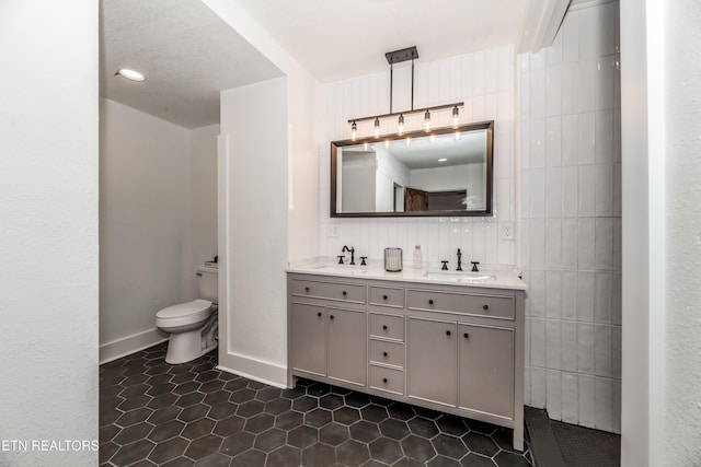 bathroom with vanity, tile patterned floors, tile walls, and toilet