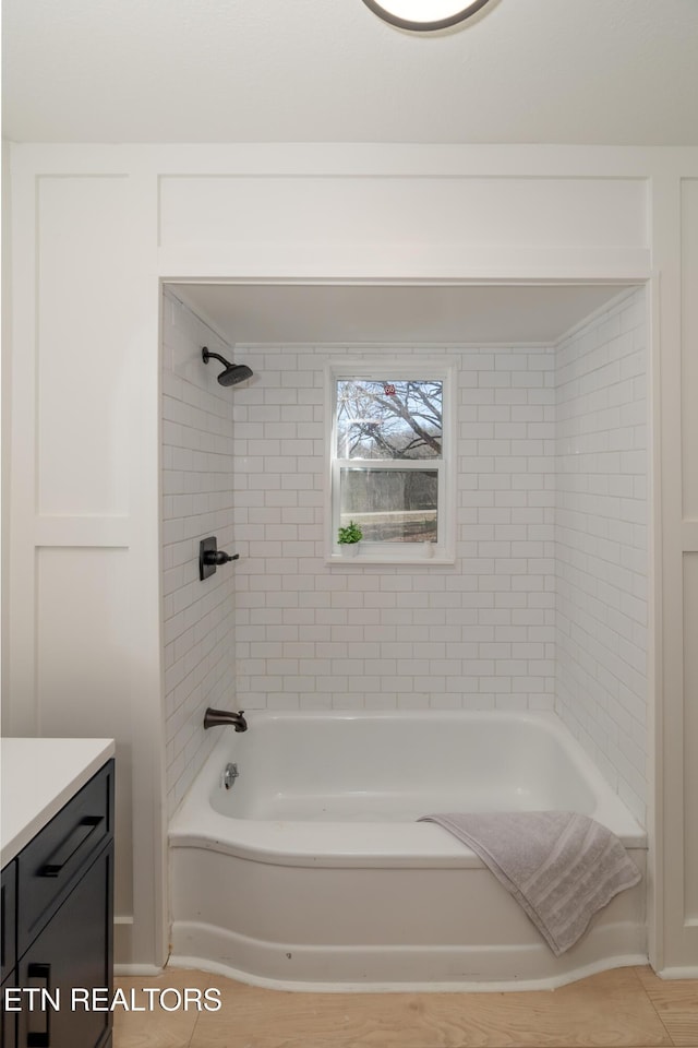 bathroom featuring tiled shower / bath combo and vanity