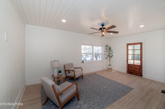 sitting room featuring hardwood / wood-style flooring, ornamental molding, and a healthy amount of sunlight