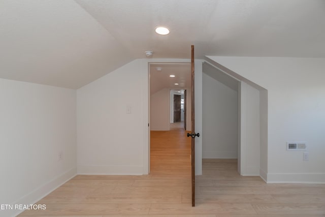 bonus room featuring light hardwood / wood-style flooring and vaulted ceiling