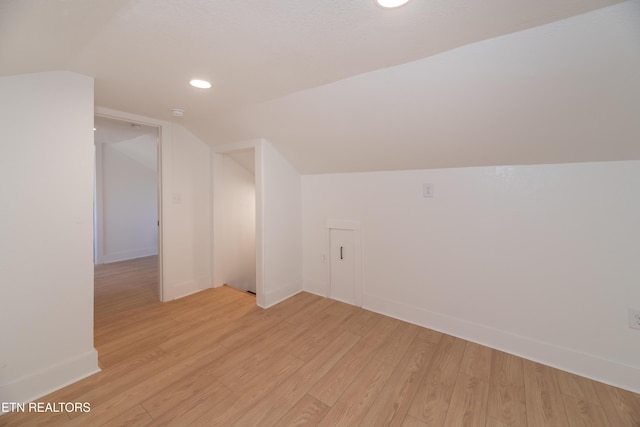 bonus room with vaulted ceiling and light hardwood / wood-style floors