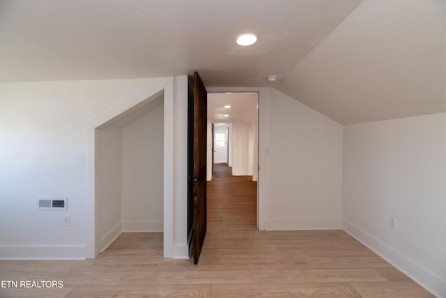 bonus room with lofted ceiling and light hardwood / wood-style floors