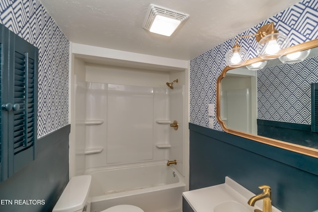 full bathroom featuring shower / tub combination, vanity, toilet, and a textured ceiling