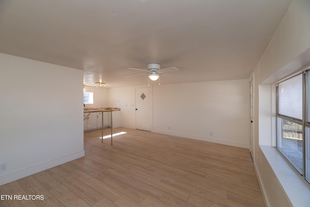 empty room with ceiling fan and light hardwood / wood-style flooring