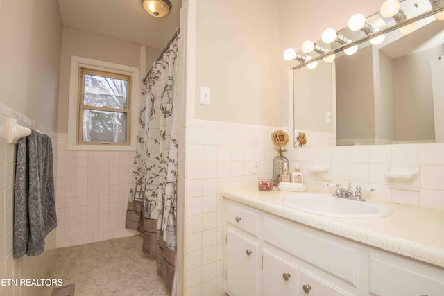 bathroom with vanity, a shower with shower curtain, and tile walls