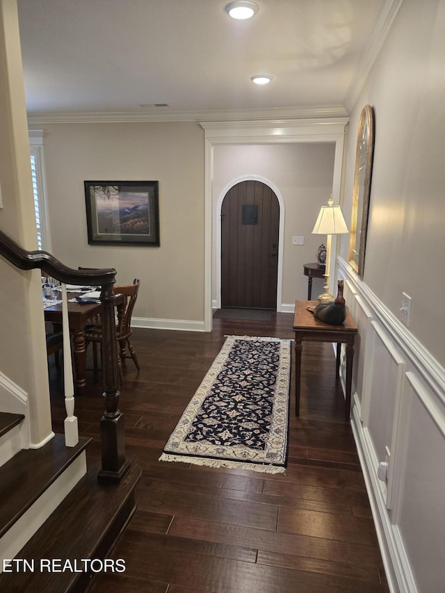 foyer entrance with crown molding and dark hardwood / wood-style floors