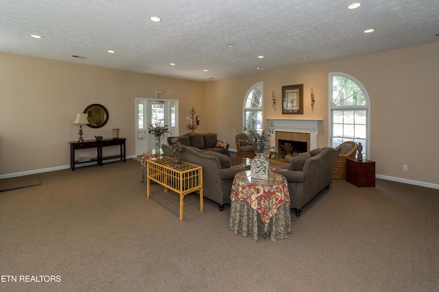 carpeted living room with a healthy amount of sunlight, a tile fireplace, and a textured ceiling