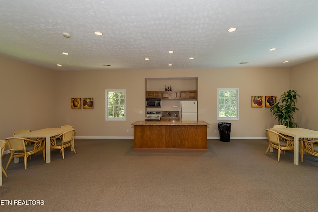 carpeted office featuring a textured ceiling